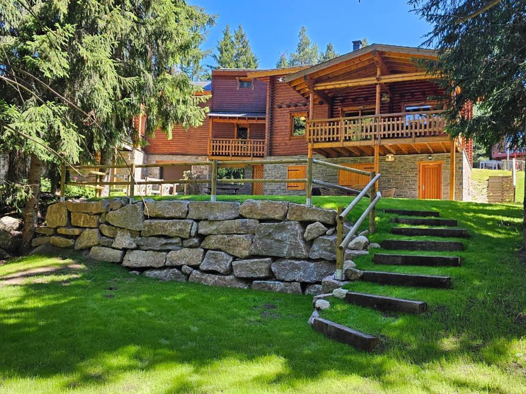 Cette maison en rondins est dotée d'un mur et d'escaliers en pierre. dans l'établissement Chalet de charme authentique, à Bolquère-Pyrénées 2000
