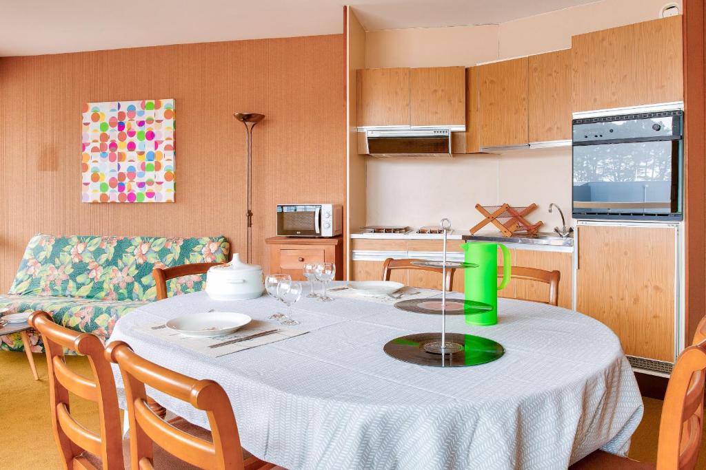 une cuisine et une table avec un chiffon de table blanc dans l'établissement À 200m de la plage, appartement vue mer pour 4, à Bénodet