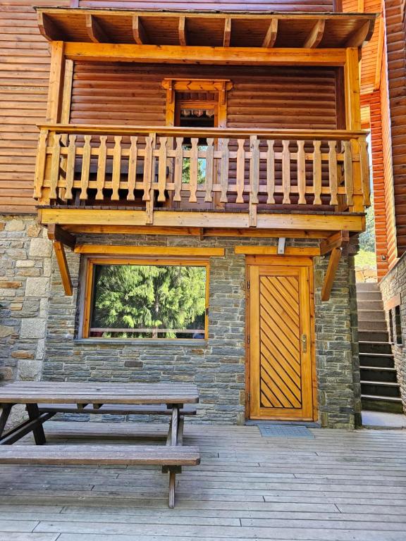 une cabine en bois avec une terrasse et un banc dans l'établissement Chalet bois 45M2, à Bolquère-Pyrénées 2000