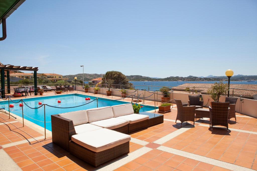 une terrasse avec un canapé et une piscine dans l'établissement Hotel Miralonga, à La Maddalena