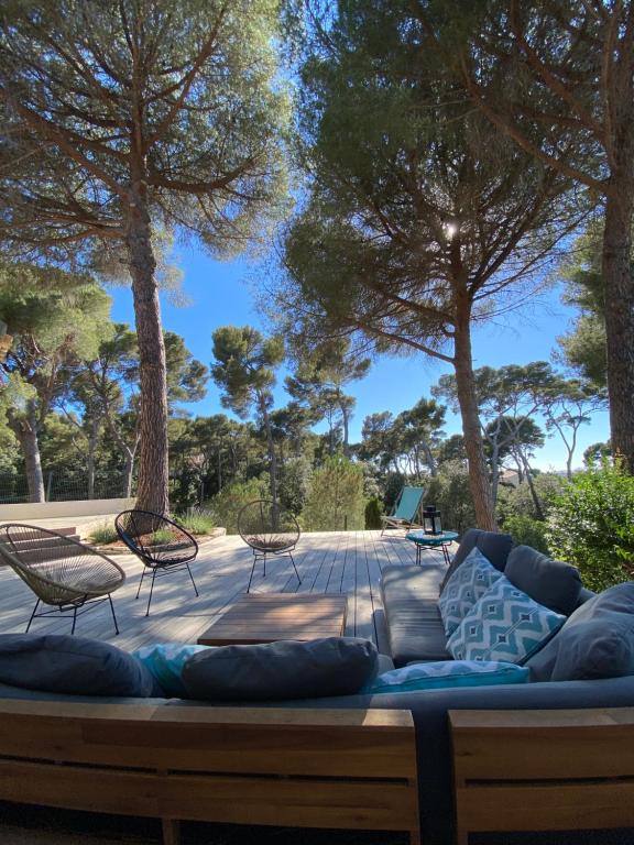 une terrasse avec un canapé, des chaises et des arbres dans l'établissement les Alizés, à Marseille