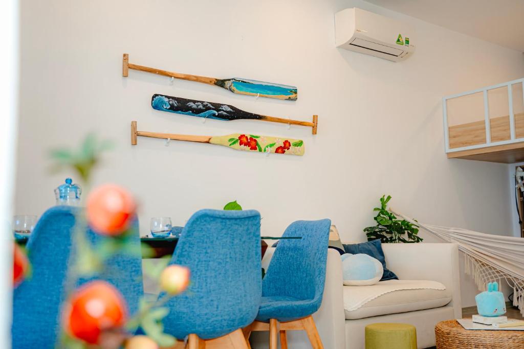 a living room with blue chairs and a couch at Sunrise from bed Apartment - NhaTrang Beach in Nha Trang