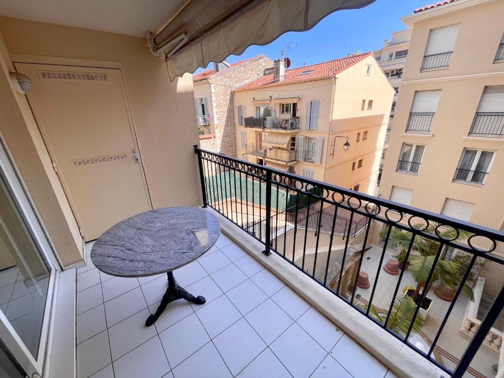 un balcon avec une table et une vue sur une ville dans l'établissement Le Palazzio by Connexion, à Cannes