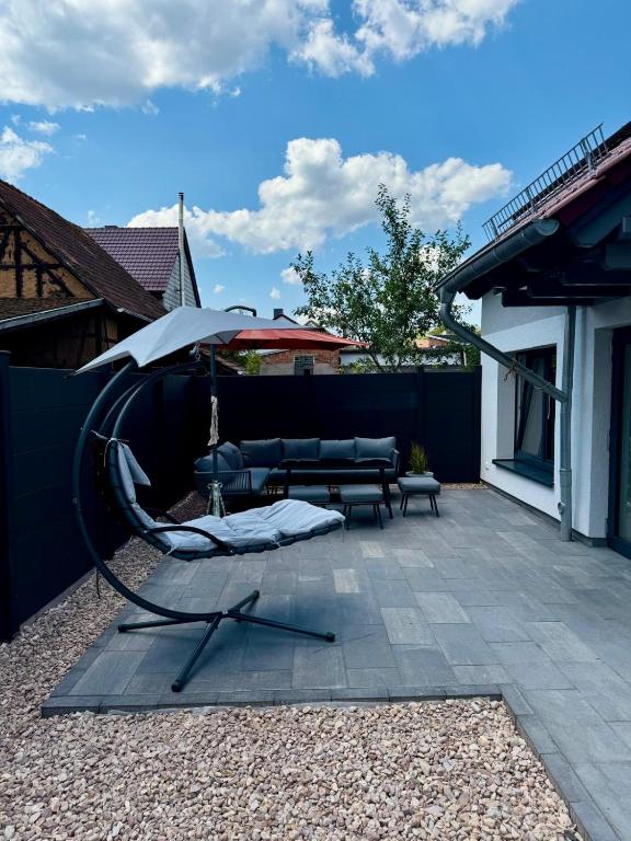 a patio with an umbrella and a couch and a bench at Ganzes Tiny House "Thüringer Ruhe" mit großem Garten nahe Rennsteig in Laucha