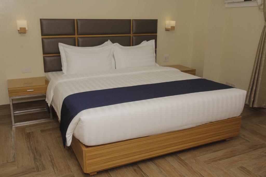 فندق صن ستار غراند  في مانيلا: سرير في غرفة الفندق بسرير ابيض كبير