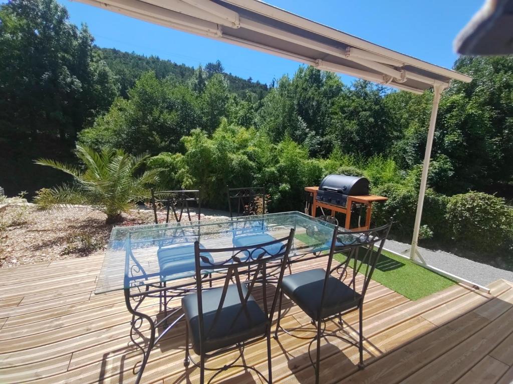 a patio with chairs and a grill on a deck at Gîte La Bauge 1 à 7 personnes 26400 Montclar sur Gervanne in Montclar-sur-Gervanne