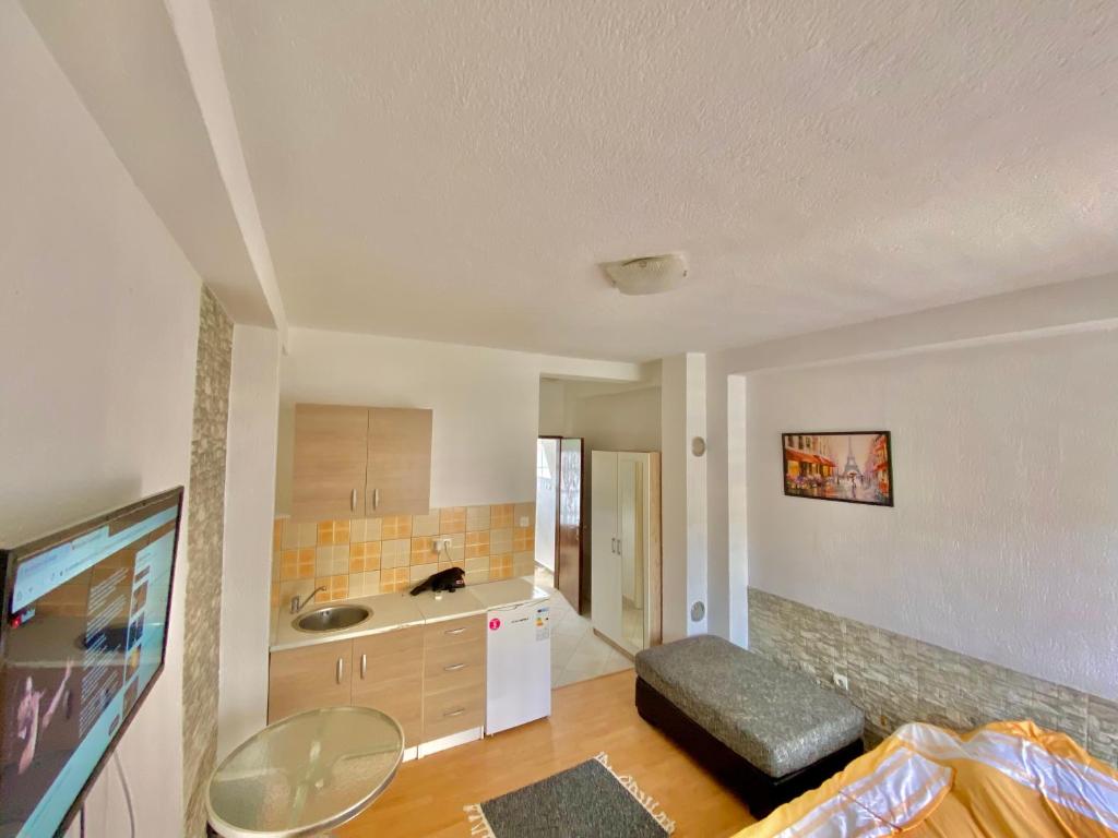 a room with a kitchen with a sink and a refrigerator at Apartman LITTLEHOME Travnik in Travnik