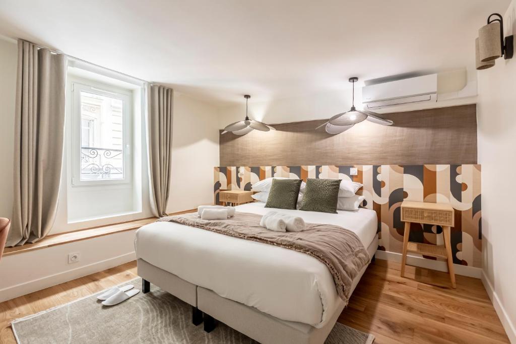 une chambre avec un grand lit et une fenêtre dans l'établissement Sweett - Casanova, à Paris