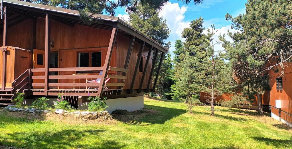 Ce chalet en bois dispose d'une terrasse couverte et d'une cour. dans l'établissement Confortable Chalet Mitoyen, à Bolquère-Pyrénées 2000