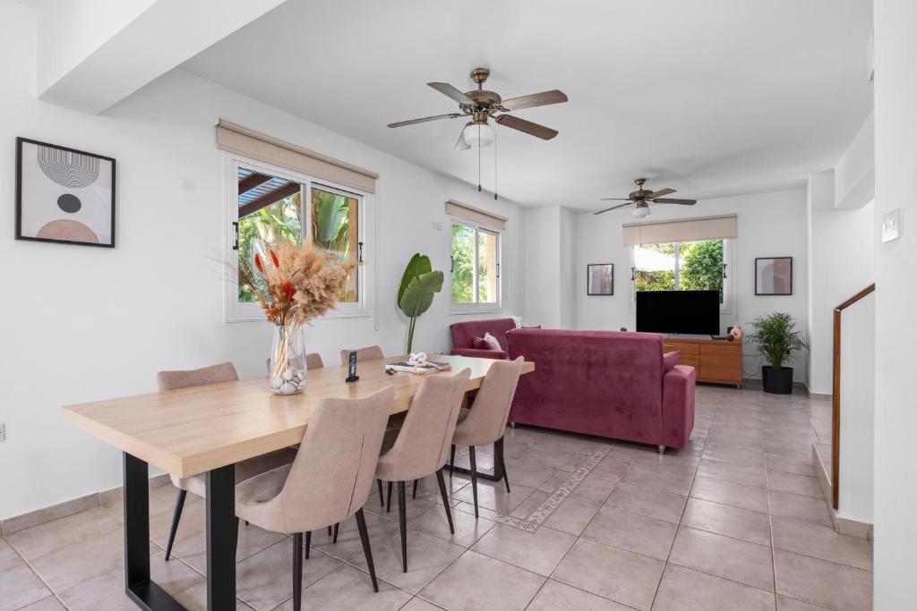 a dining room and living room with a table and chairs at Aqua Verde Luxury Villa by Nomads in Protaras