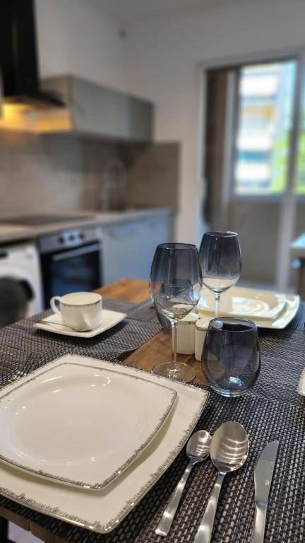 - une table avec deux assiettes et deux verres à vin dans l'établissement Le Tolstoï chic, à Villeurbanne