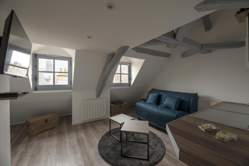 un salon avec un canapé bleu et une table dans l'établissement L'Authentique, à Rennes