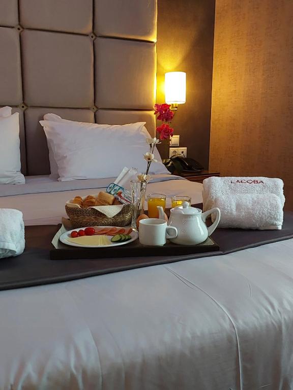 a tray of food on a bed with a breakfast at Lacoba Hotel in Athens