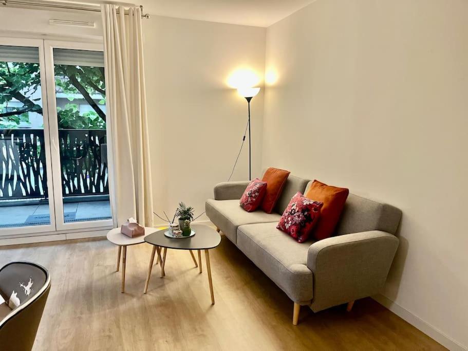 un salon avec un canapé et une table dans l'établissement Location appartement ou chambre à 25 min de Paris, à Villemomble