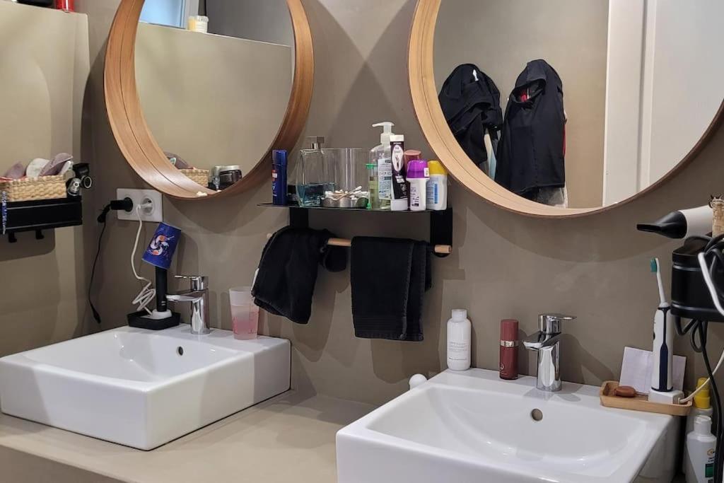 une salle de bain avec deux lavabos et deux miroirs dans l'établissement Maison Familiale, à Bidart