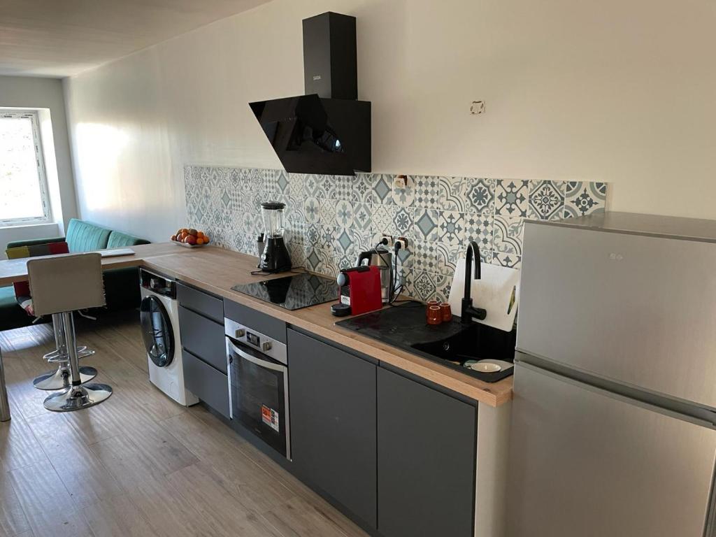 une cuisine avec un réfrigérateur et un plan de travail dans l'établissement Nid de la lègue, à Saint-Hilaire-de-Brethmas