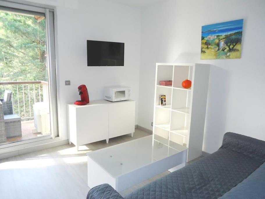 un salon blanc avec un canapé et une télévision dans l'établissement Bel appartement 2 pièces climatisé 500m centre, à Cavalaire-sur-Mer