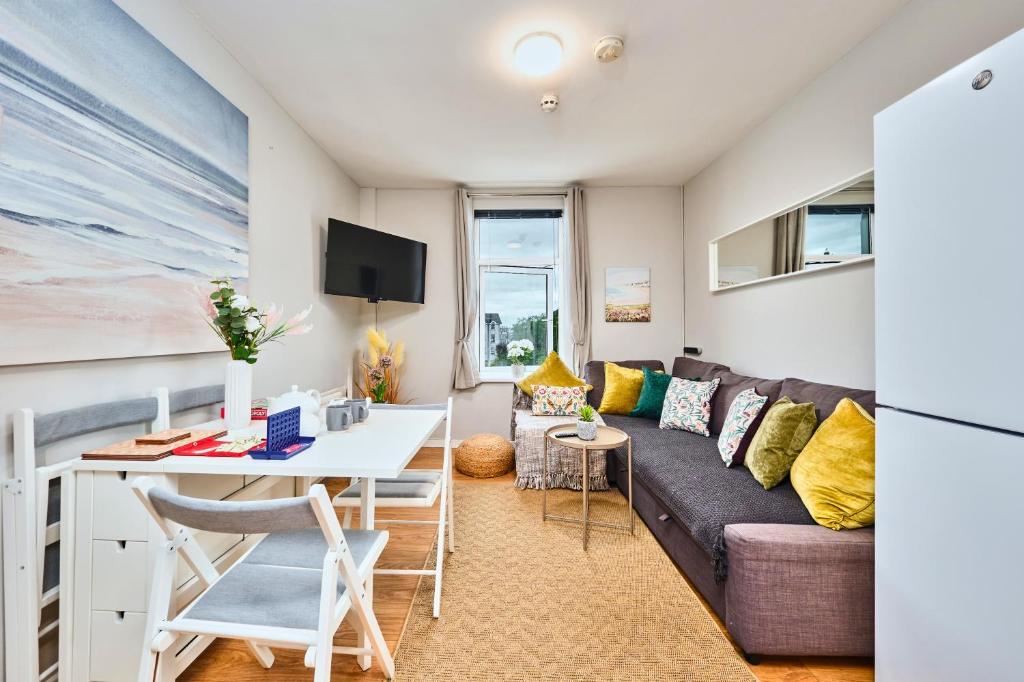 ein Wohnzimmer mit Sofa und Tisch in der Unterkunft Princess Green 5 - Portrush by the Sea in Portrush