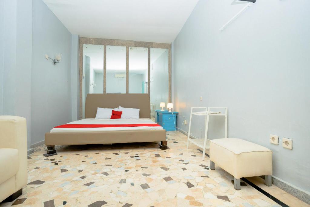 a bedroom with a bed and a chair in it at RedDoorz near RSUD Kota Mataram in Mataram