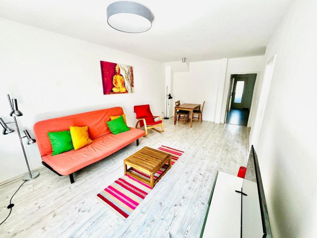 a living room with an orange couch and colorful pillows at Apartment in Bergisch Gladbach in Bergisch Gladbach
