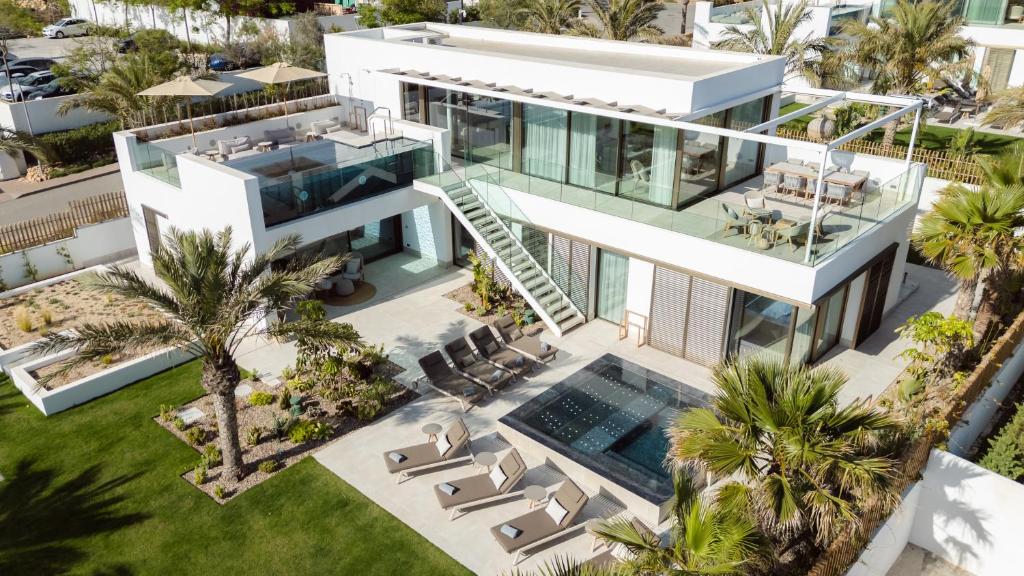 an aerial view of a house with a swimming pool and palm trees at 7Pines Resort Ibiza, part of Destination by Hyatt in San Jose