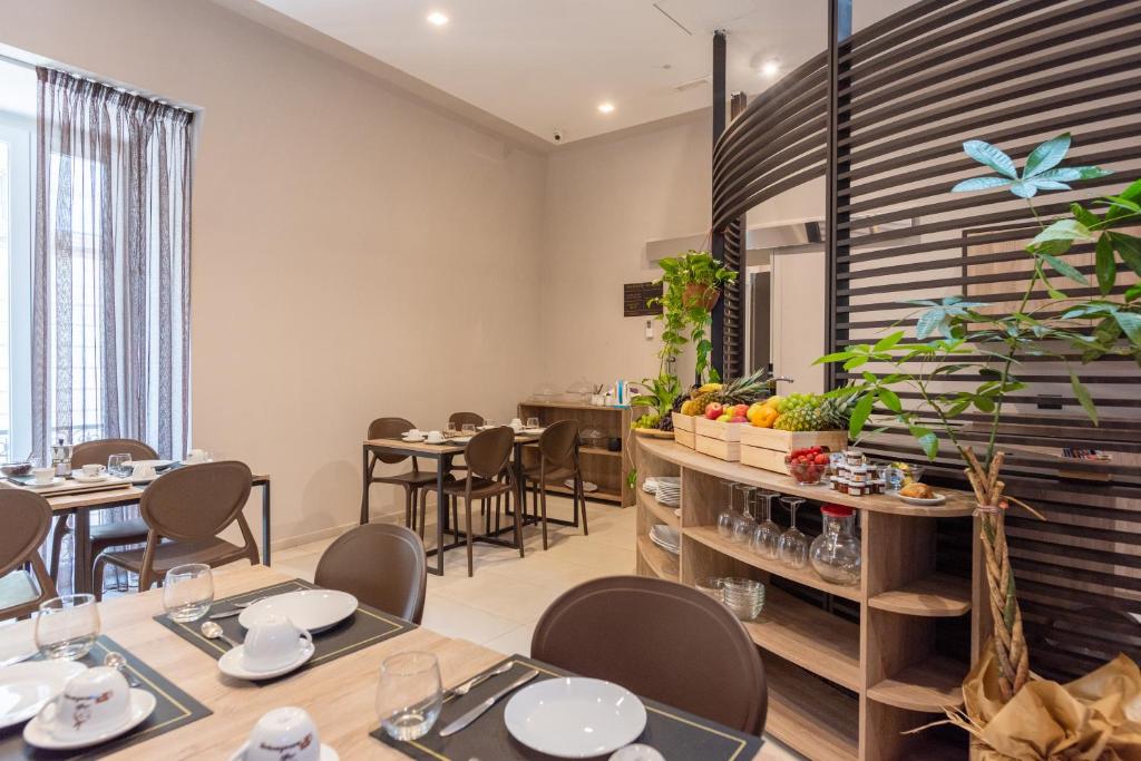 restauracja ze stołami i krzesłami w pokoju w obiekcie Neapolis Lifestyle w mieście Neapol