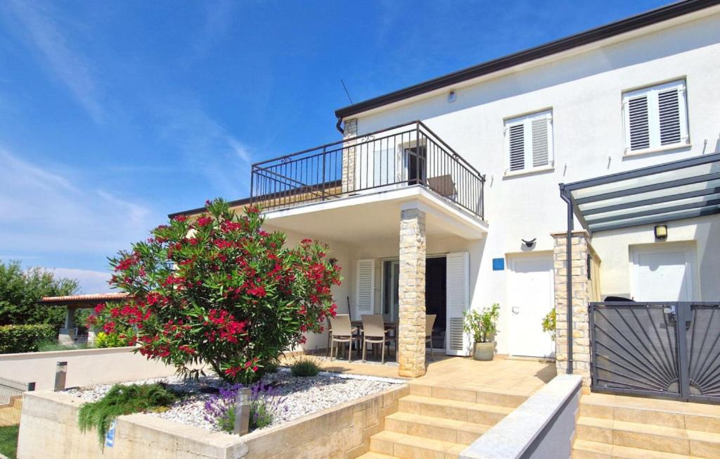 a white house with a balcony and a tree at Beautiful Villa Piccolo Paradiso in Novigrad in Bužinija