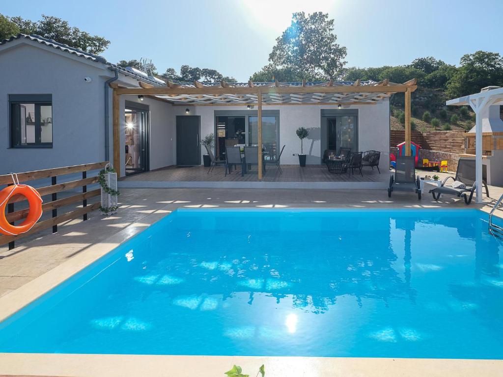 - une piscine dans une arrière-cour avec une maison dans l'établissement Villa Eleonas with private swimming pool, à Fotinós