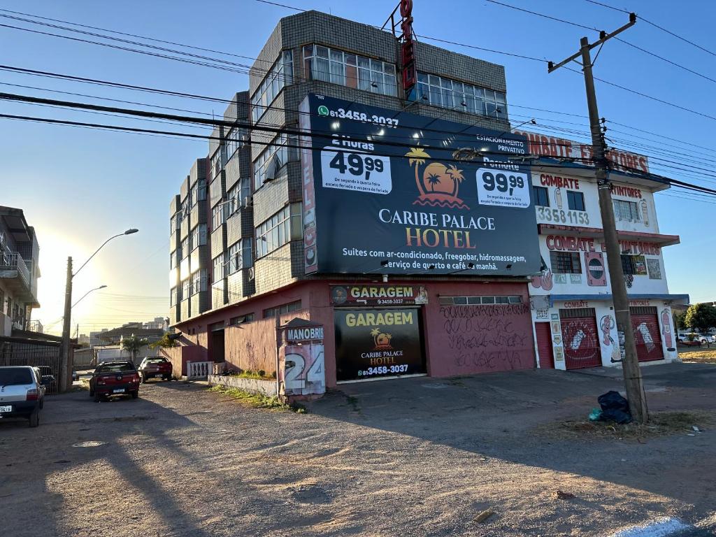 a building with a large sign on the side of it at Caribe Palace Hotel Samambaia Sul in Brasilia