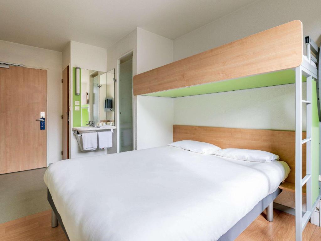 Postel nebo postele na pokoji v ubytování Ibis Budget Lyon Est Saint Quentin Fallavier