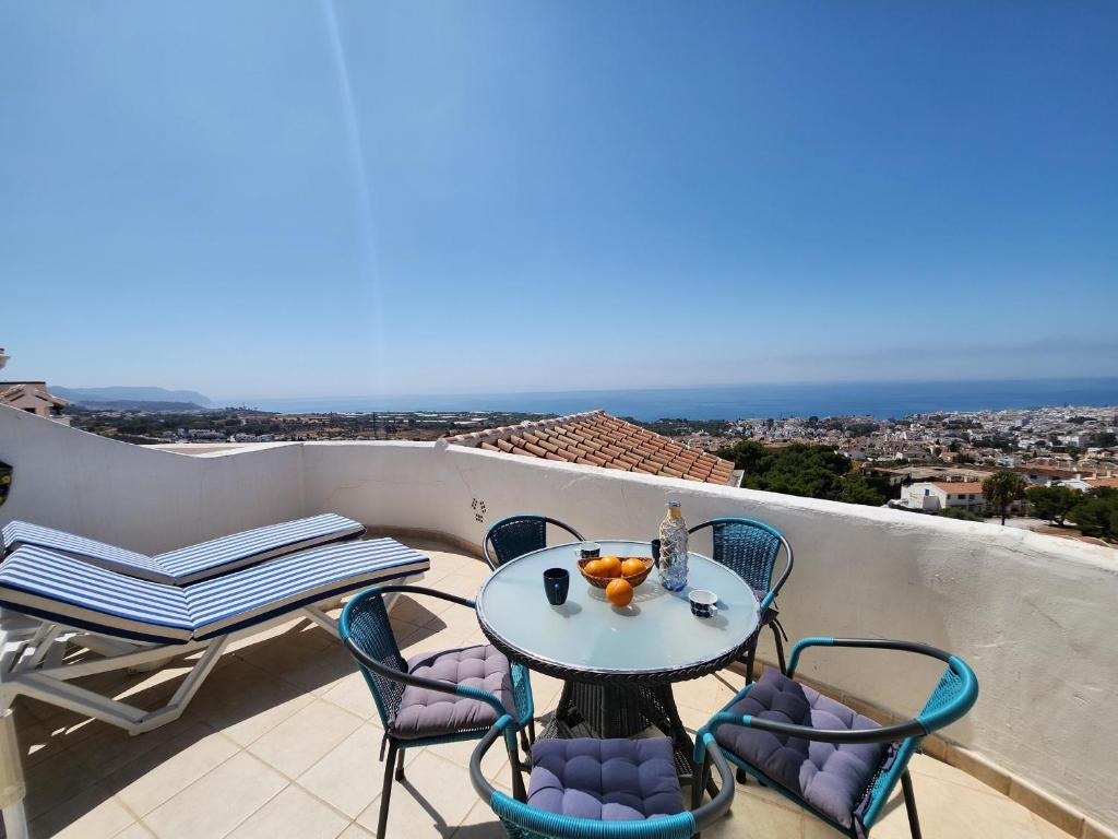 a table and chairs on a balcony with a view of the ocean at R1370 Mandarinos 61 in El Molino