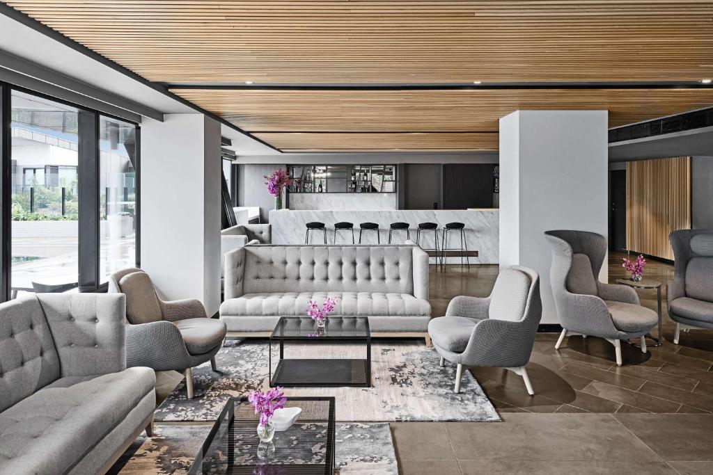 a living room with couches and chairs and a bar at Vibe Hotel Melbourne Docklands in Melbourne