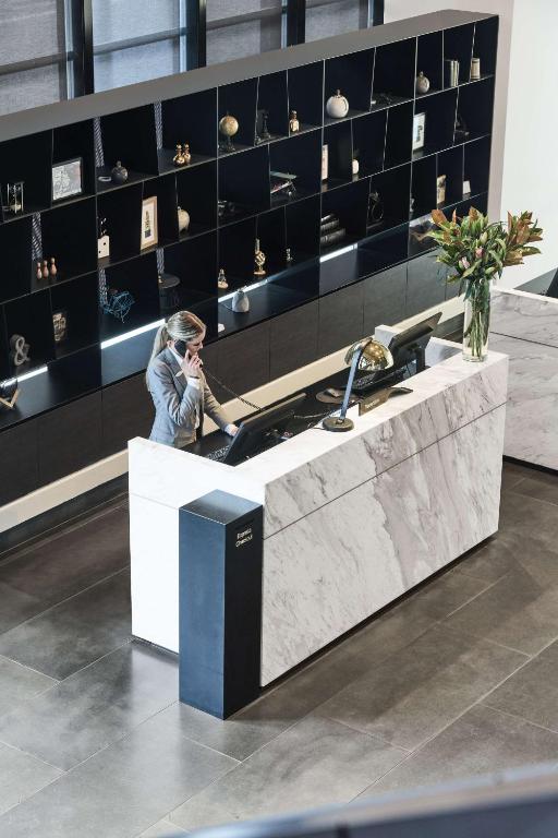 a woman talking on a cell phone at a counter in a store at Vibe Hotel Melbourne Docklands in Melbourne