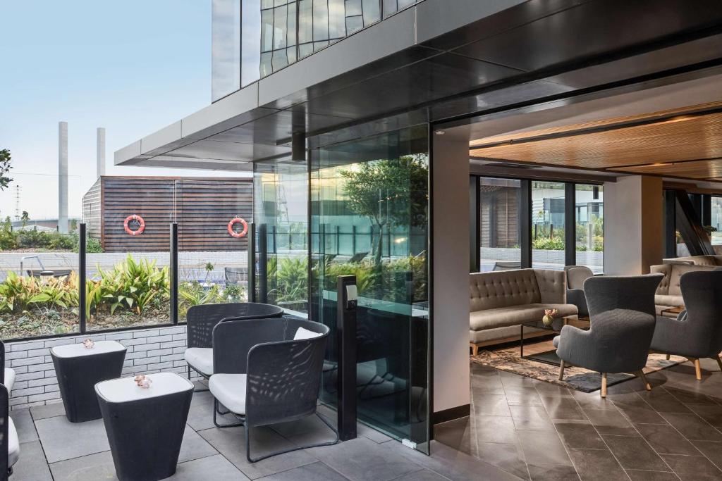 a restaurant with chairs and tables in a building at Vibe Hotel Melbourne Docklands in Melbourne