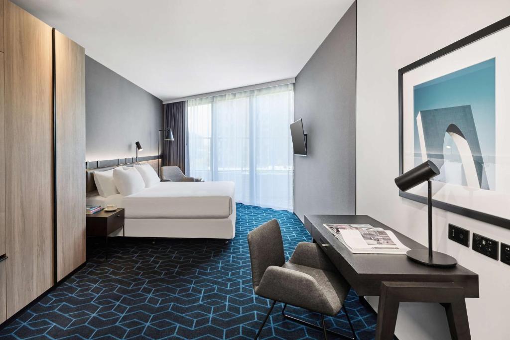 a hotel room with a bed and a desk at Vibe Hotel Melbourne Docklands in Melbourne