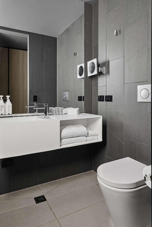 a bathroom with a tub and a toilet and a sink at Vibe Hotel Melbourne Docklands in Melbourne