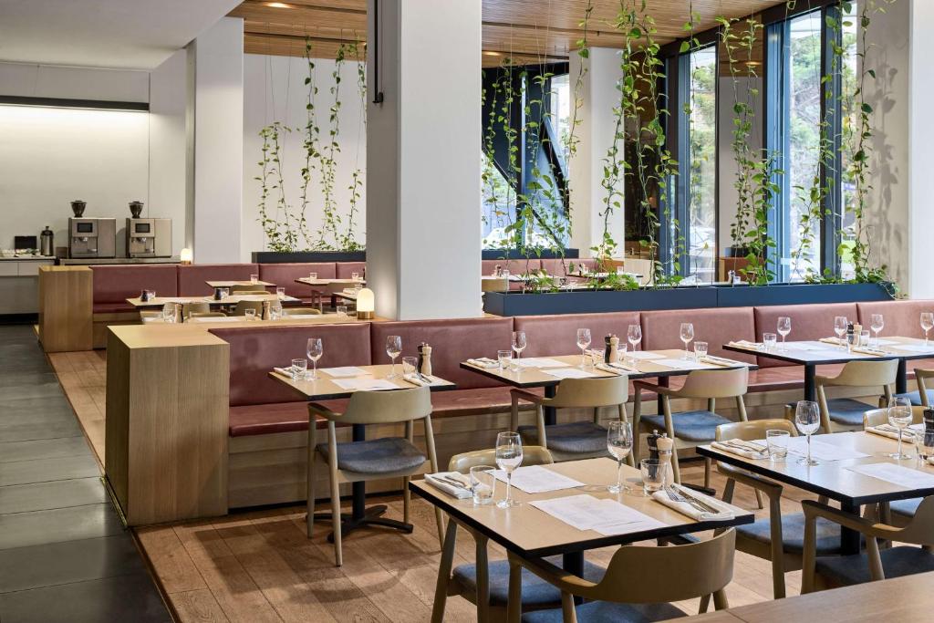 a restaurant with tables and chairs and a bar at Vibe Hotel Melbourne Docklands in Melbourne