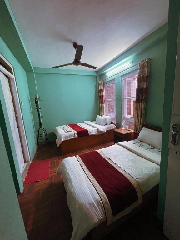 Postel nebo postele na pokoji v ubytování Hotel New Pokhara Peace