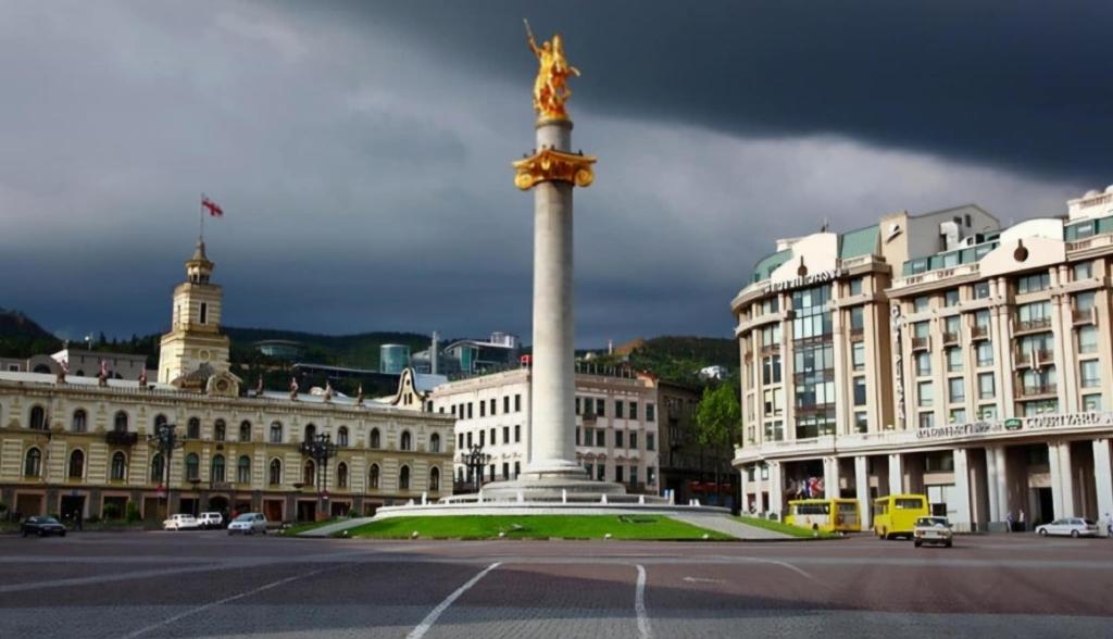 Una statua in mezzo a una strada di fronte a un edificio di apartment on leonidze 18 a Tbilisi City