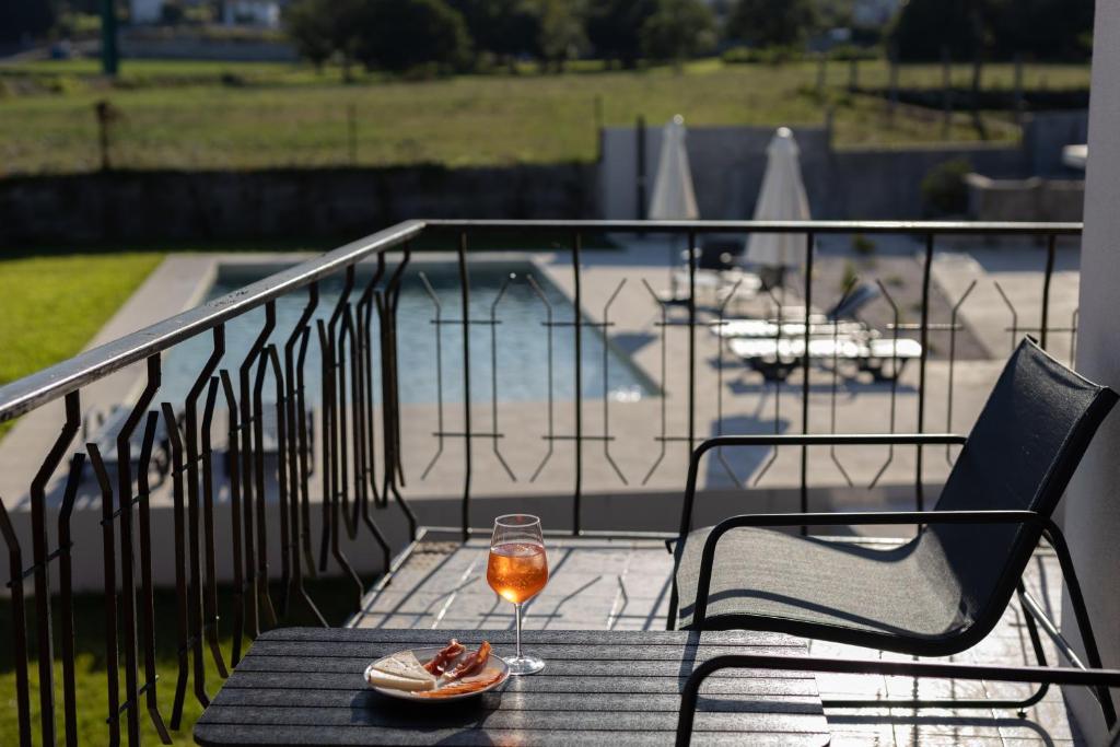 een glas wijn op een tafel op een balkon bij Correia Villa in Barcelos