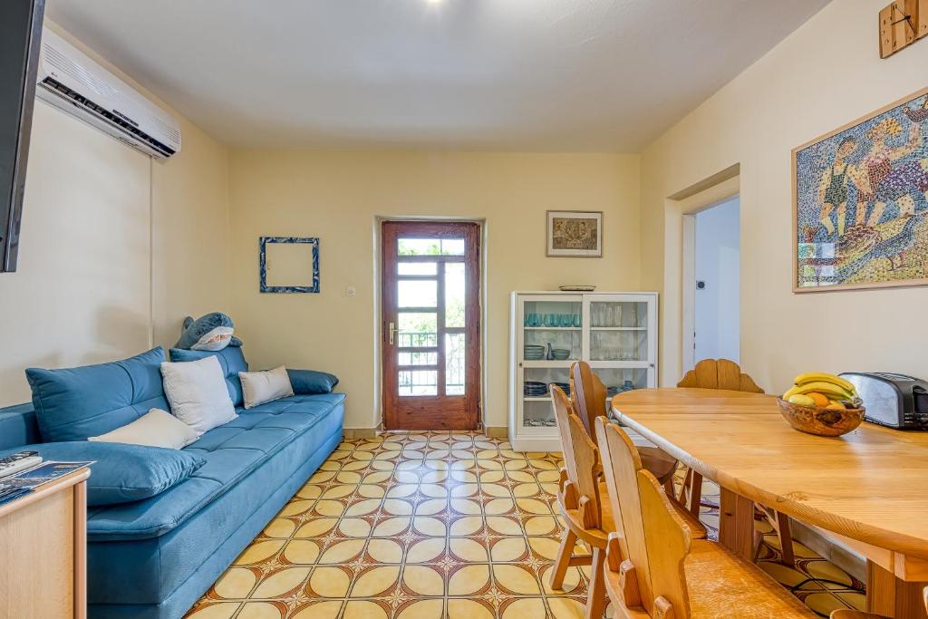 a living room with a blue couch and a table at Old Bay Leave Town Apartment - Happy Rentals in Mali Lošinj