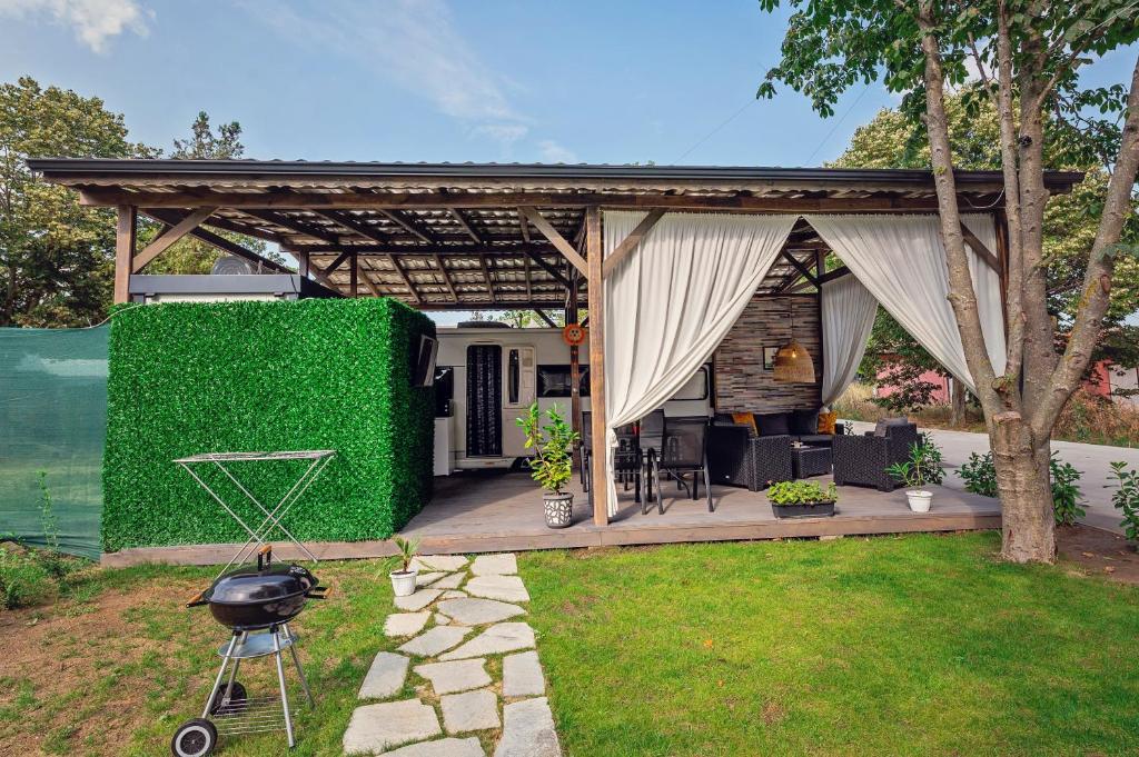 a pergola with a grill in a yard at Каравани AVI IRIS Фичоза in Varna City