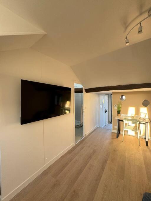 un salon avec une télévision à écran plat sur un mur dans l'établissement Le Rooftop - Terrasse vue Cathédrale - Netflix, à Orléans
