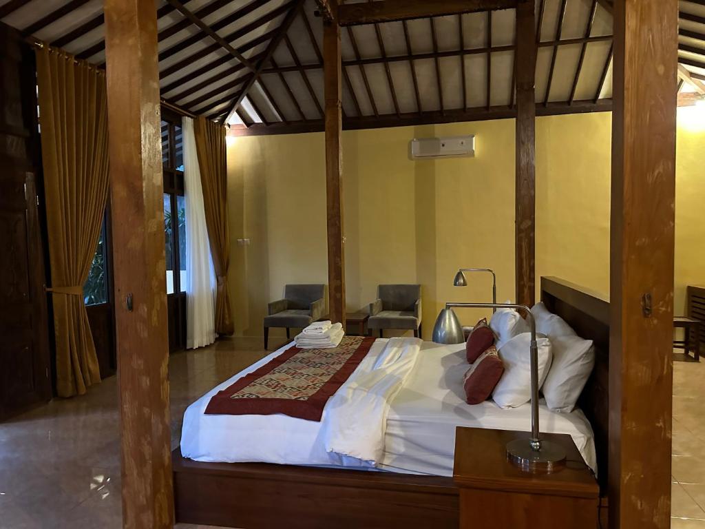 Postel nebo postele na pokoji v ubytování Kampoeng Joglo Abangan Ubud