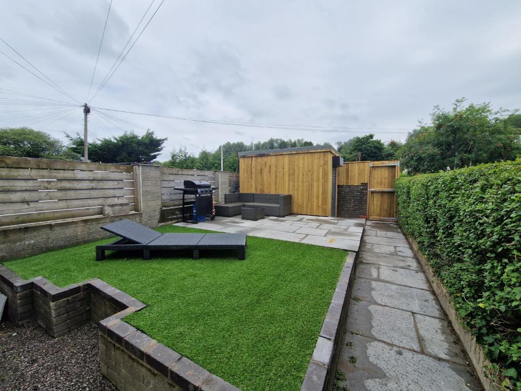 a small garden with green grass in a backyard at Homely 3 Bedroom home near town centre & only 1 mile from Bike Park Wales in Merthyr Tydfil