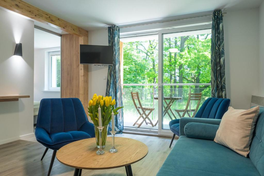 a living room with a couch and a table with flowers at VacationClub - Podgórzyńska 6A Apartament 5 in Jelenia Góra