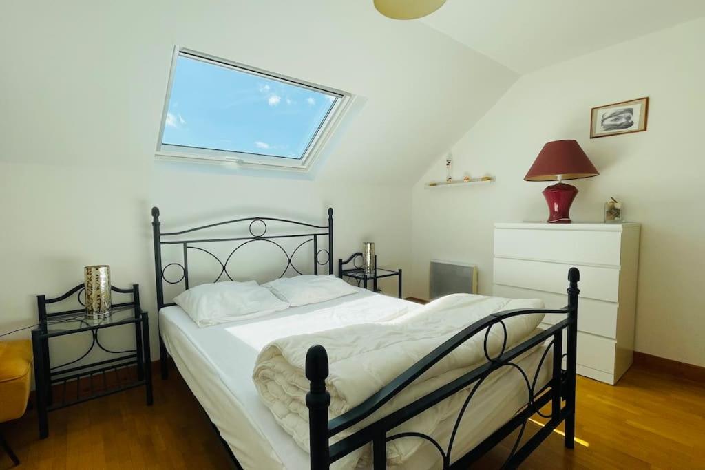 a bedroom with a black bed and a window at Charming family home in Couëron in Couëron