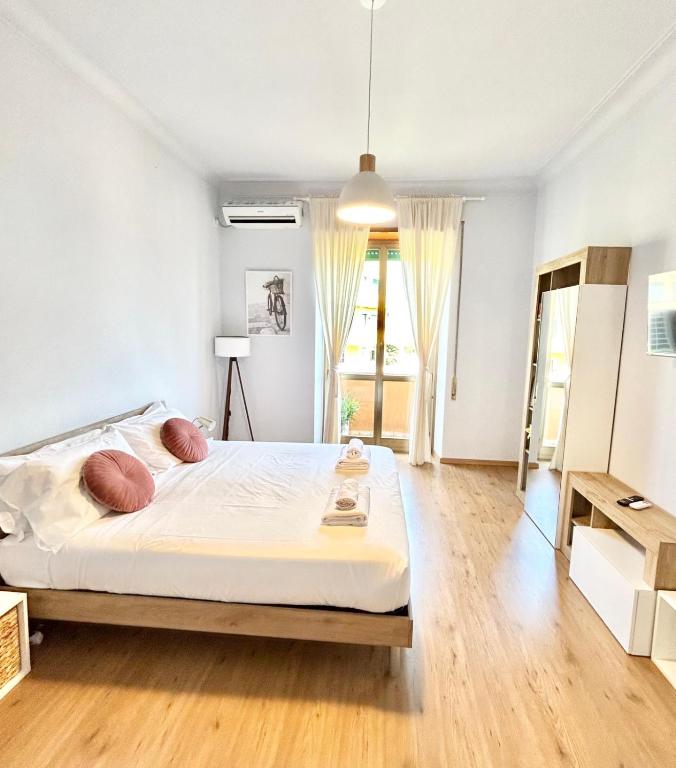 a bedroom with a large white bed and wooden floors at Flaminio Luxury Home - City Center in Rome