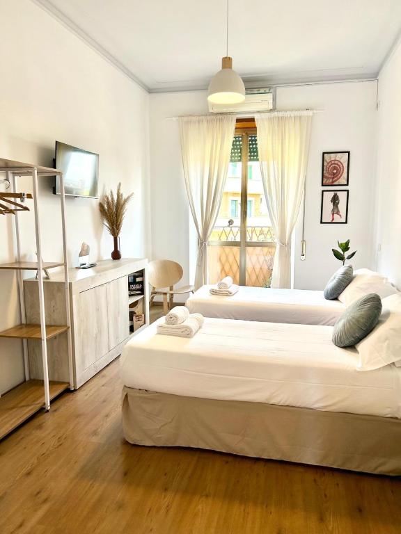 a bedroom with two beds and a desk and a window at Flaminio Luxury Home - City Center in Rome