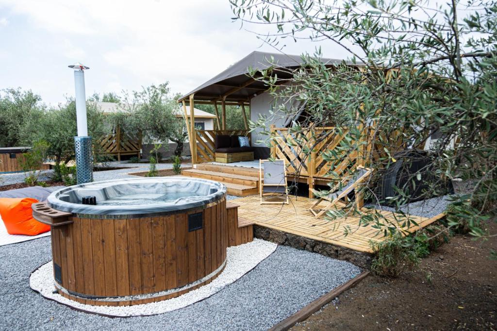 a hot tub in a yard with a tent at Koru Etna Glamping - lodge con vasca idromassaggio privata in Ragalna